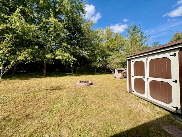 a backyard of a house with yard and wooden fence