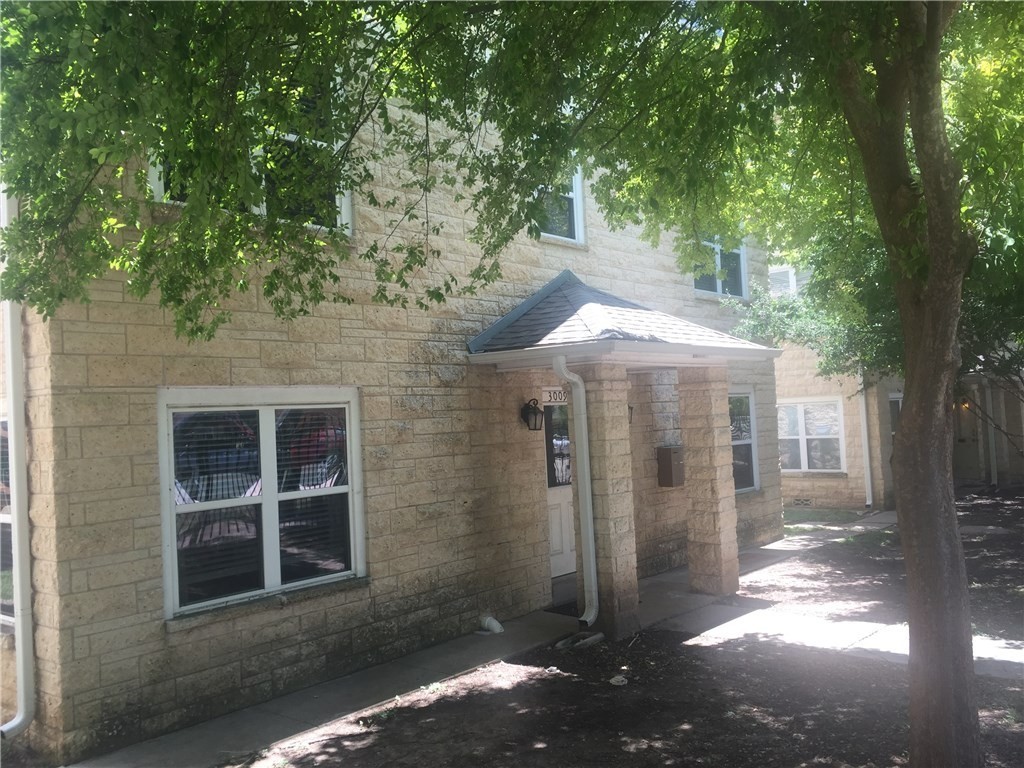 a view of a large tree in front of a house