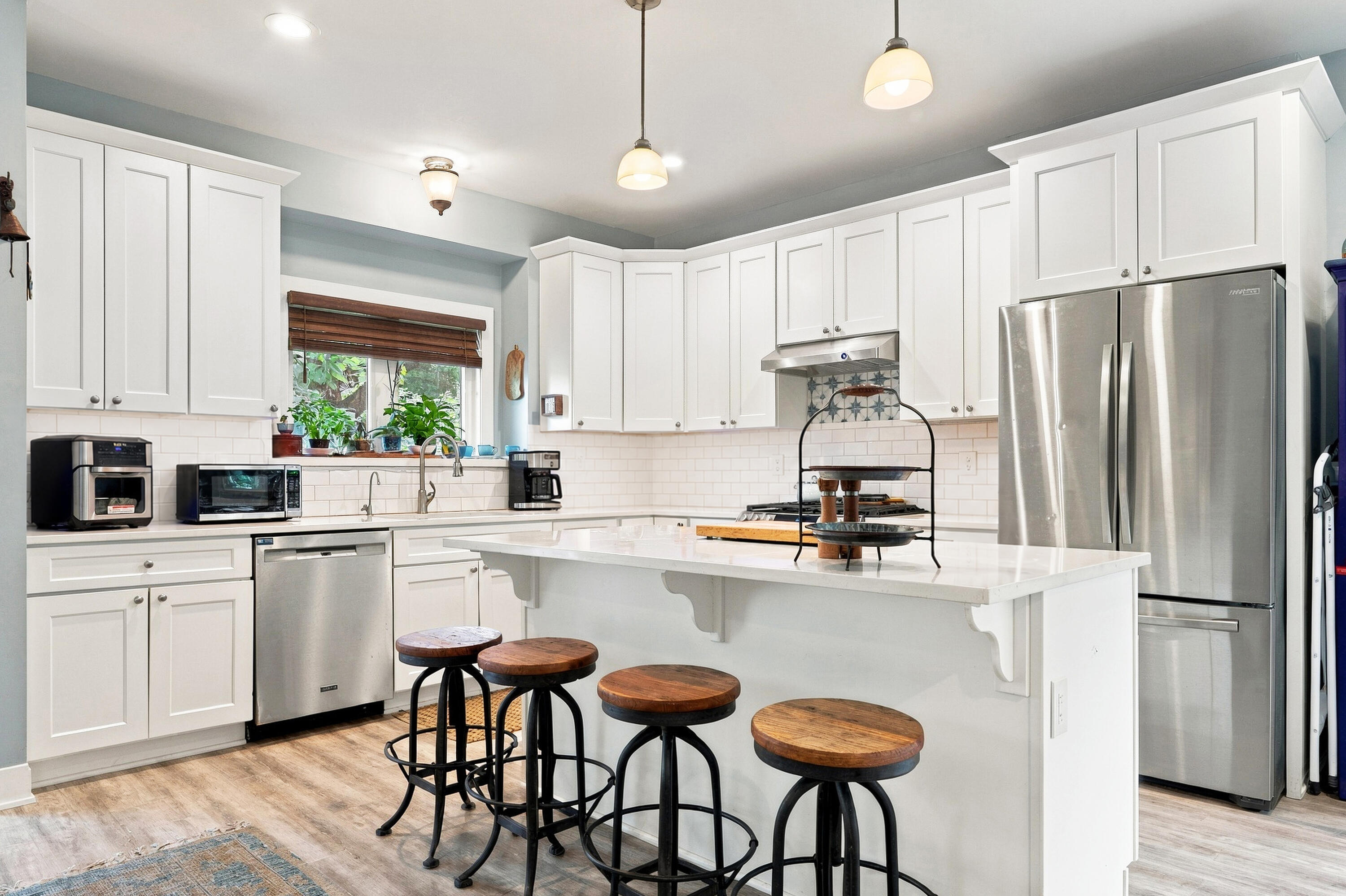 78 Menominee Road Williams Bay, WI 53191 - Photo 5 of 40 This fabulous island kitchen features quartz countertops, Stainless Steel appliances, subway tile backsplash, under cabinet lighting, garden ledge window over the sink, crown molding on the cabinets and LVP plank flooring.