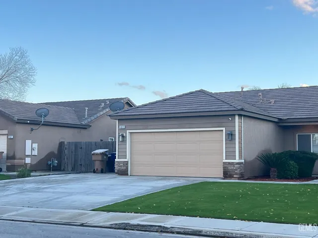 a front view of a house with a yard and a garage