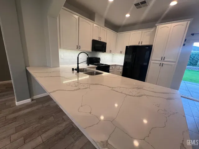 a kitchen with stainless steel appliances a refrigerator sink and microwave