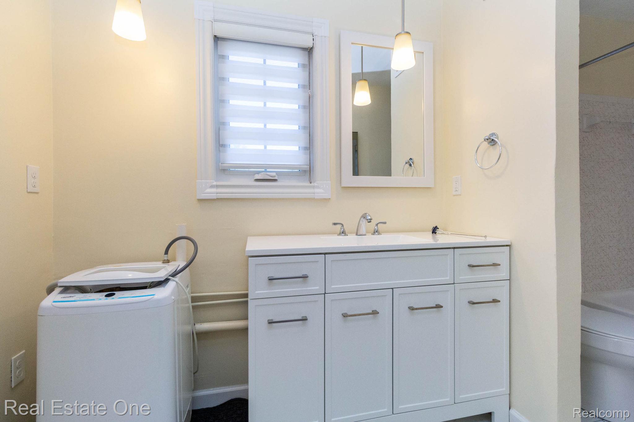 111 Manor Way Rochester, MI 48309 - Photo 23 of 36 Bathroom featuring a white vanity with integrated sink, chrome faucet, and framed mirror