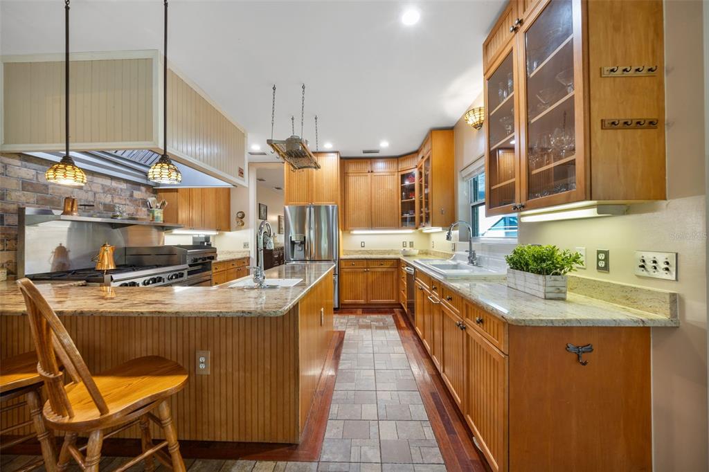 37810 Boyd Road Myakka City, FL 34251 - Photo 20 of 98 a kitchen with stainless steel appliances granite countertop a sink a stove and a wooden cabinets