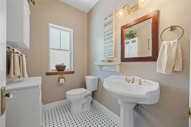 a bathroom with a sink a toilet and a mirror