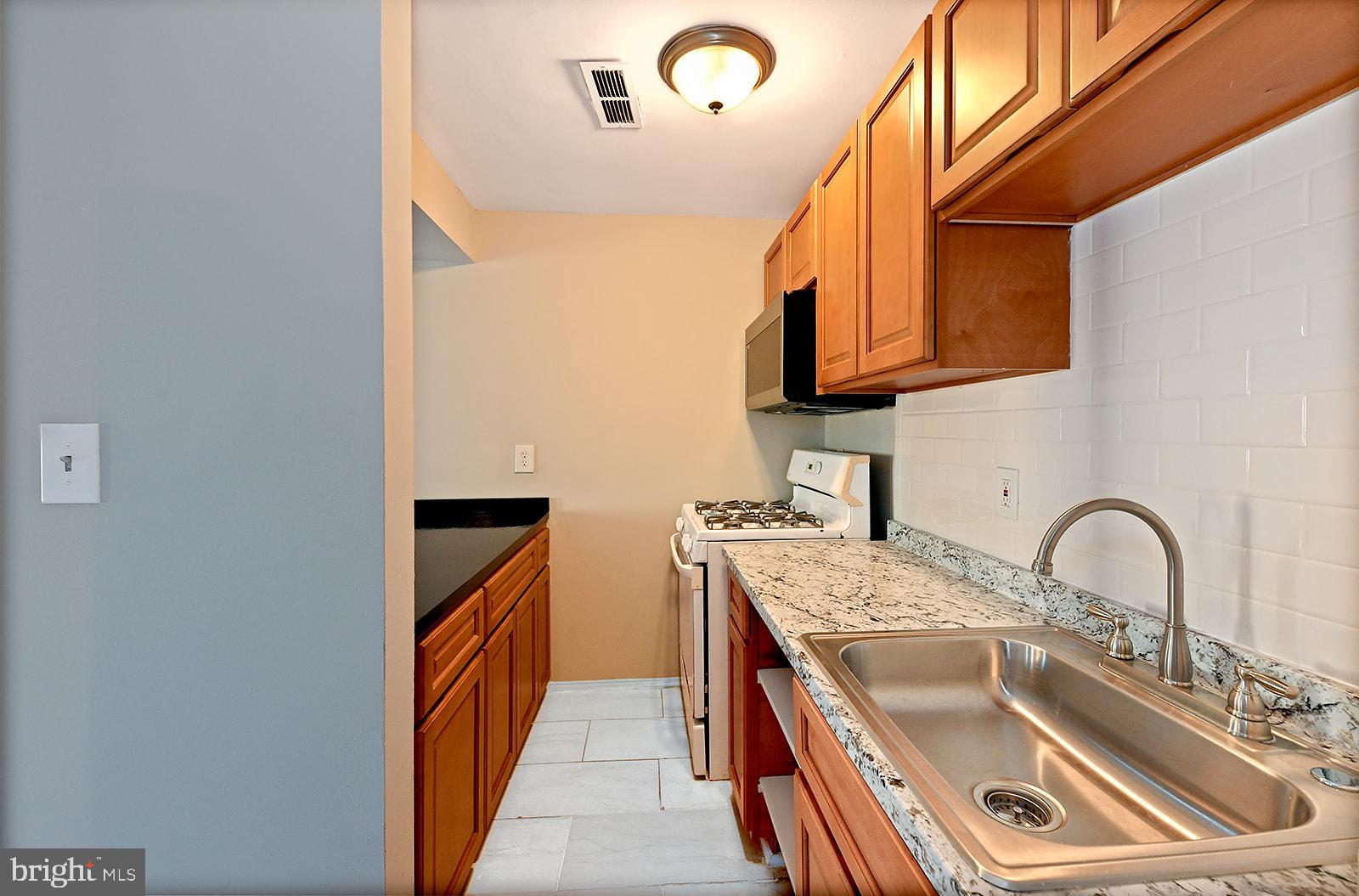1436 West Baltimore Street, Unit 2 Baltimore, MD 21223 - Photo 5 of 11 a kitchen that has a sink and a stove
