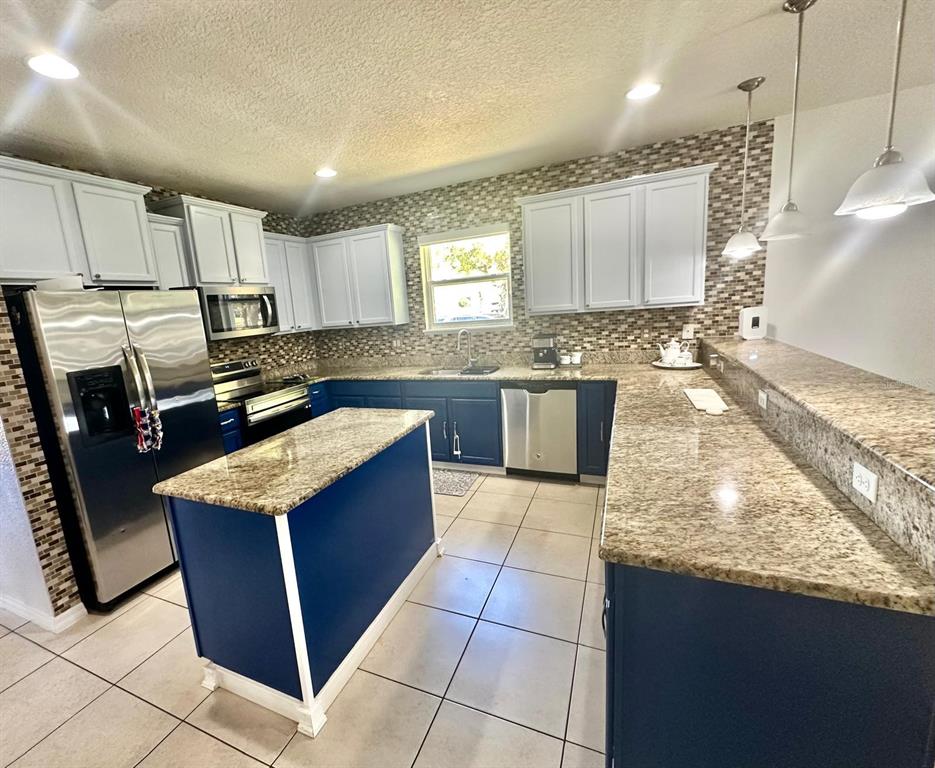 1901 Nations Way St. Cloud, FL 34769 - Photo 2 of 17 a kitchen with stainless steel appliances granite countertop stove top oven and cabinets