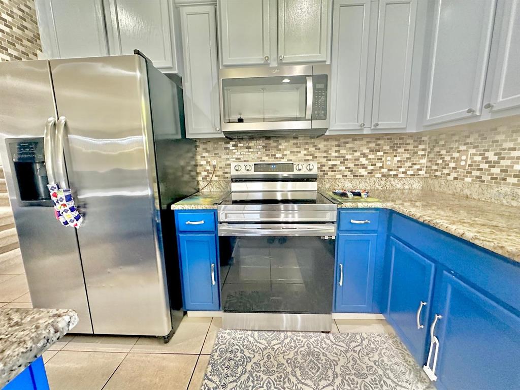 1901 Nations Way St. Cloud, FL 34769 - Photo 3 of 17 a kitchen with granite countertop a refrigerator and a stove