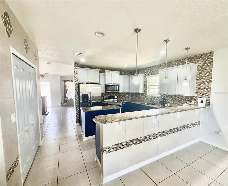 1901 Nations Way St. Cloud, FL 34769 - Photo 4 of 17 a kitchen with stainless steel appliances granite countertop a refrigerator and a sink
