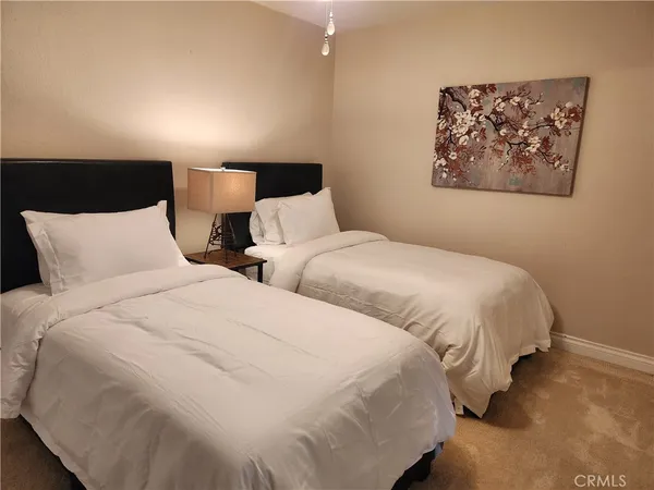 a large bed sitting in a bedroom next to a lamp