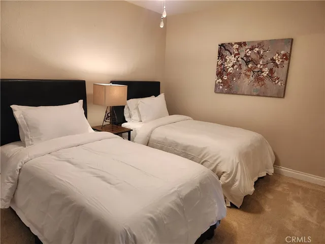 a large bed sitting in a bedroom next to a lamp