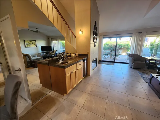 a kitchen with a stove a sink a counter top space and living room