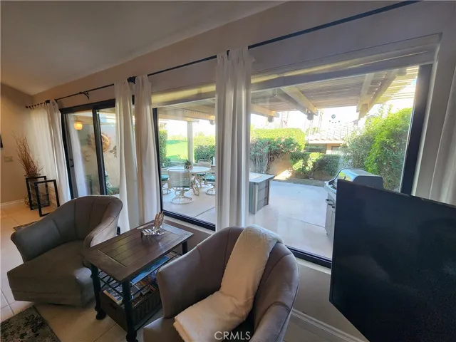 a living room with furniture and a floor to ceiling window