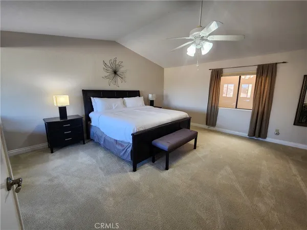 a spacious bedroom with a bed and a chandelier