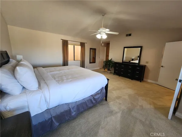 a bedroom with a bed window and dresser