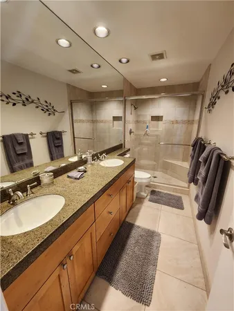 a bathroom with a granite countertop sink a mirror and a shower