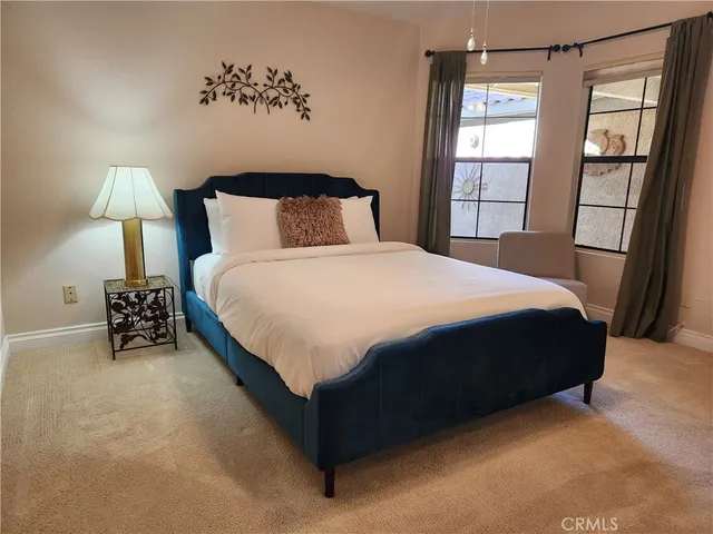 a large bed sitting in a bedroom next to a window