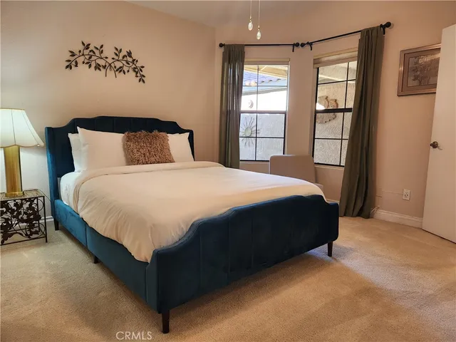 a large bed sitting in a bedroom next to a window