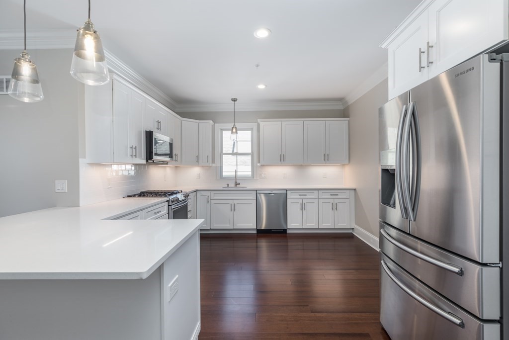 41 Wenham Street, Unit 3 Boston, MA 02130 - Photo 3 of 13 a kitchen with stainless steel appliances a refrigerator sink and cabinets