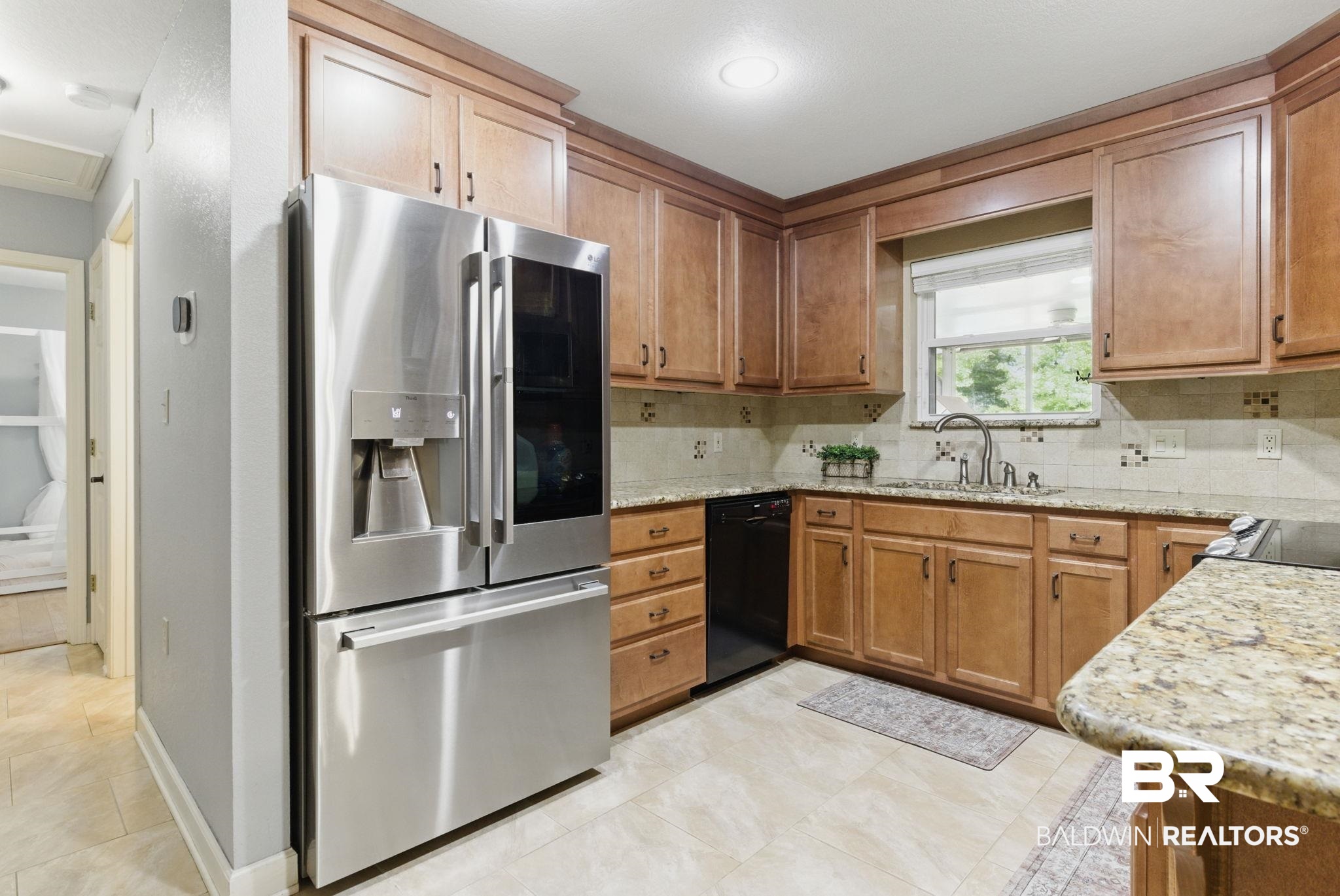 32345 River Lake Road Seminole, AL 36574 - Photo 16 of 56 Kitchen with light stone counters, backsplash, black dishwasher, stainless steel refrigerator with ice dispenser, and a sink