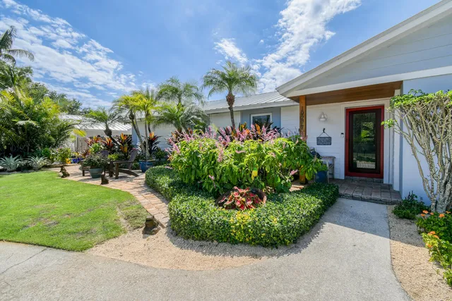 a view of a house with a yard and potted plants