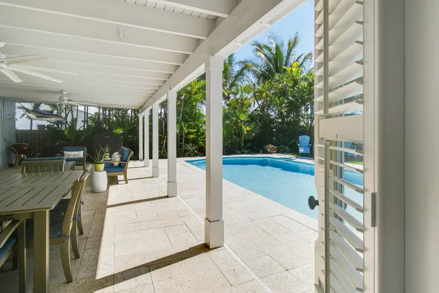 a green field with lots of flowers in front of it