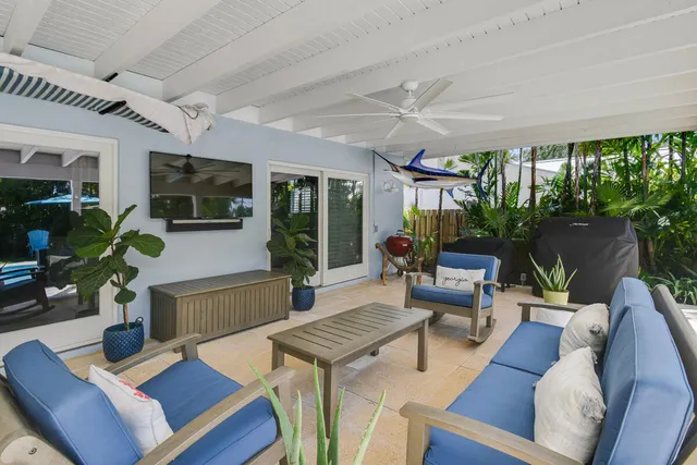 a view of a swimming pool with a yard and palm trees