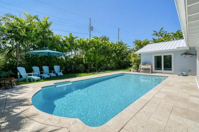 a view of an ocean with boats and trees in the background
