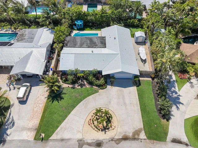 a kitchen with stainless steel appliances granite countertop a stove top oven a sink dishwasher a dining table and chairs with wooden floor