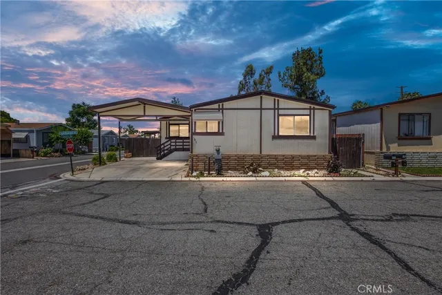a front view of a house with yard and parking