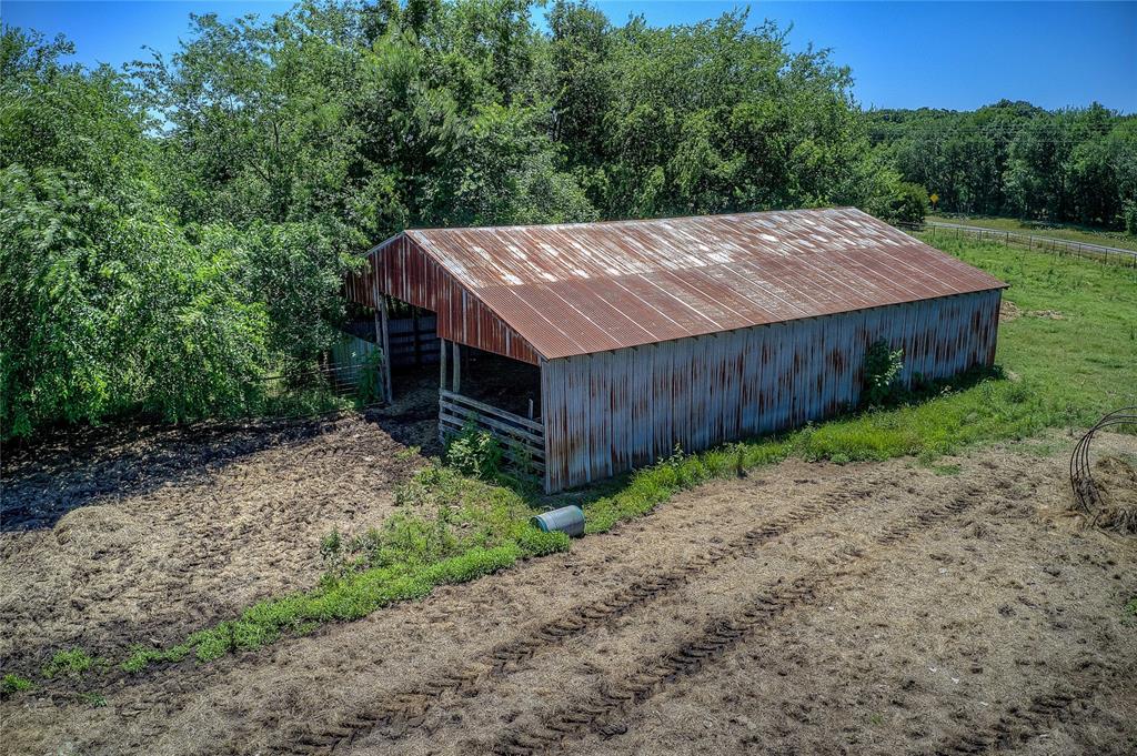3296 Farm Road 3236 Dike, TX 75437 - Photo 24 of 40 a view of a backyard with a barn and large trees