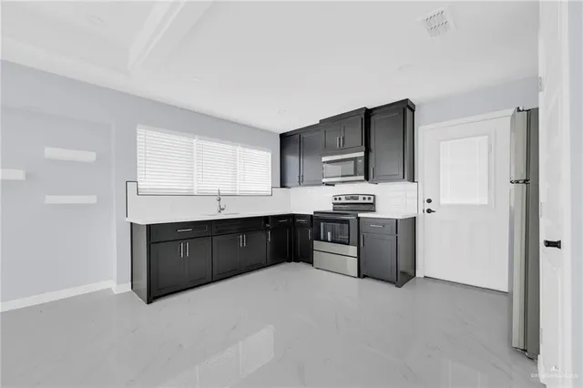 a kitchen with stainless steel appliances granite countertop a stove a sink dishwasher a refrigerator and a oven