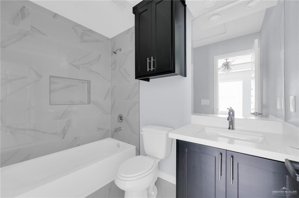 1620 Shadow Creek Drive, Unit 1 Weslaco, TX 78596 - Photo 8 of 11 a bathroom with a sink a toilet and bathtub