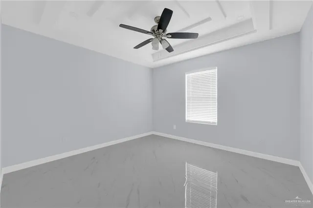 an empty room with a window and a fan