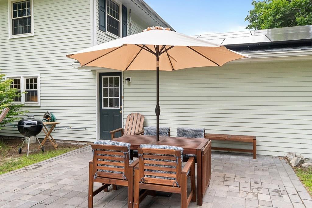 10 Craig Road Chelmsford, MA 01824 - Photo 4 of 34 a view of a patio with a table and chairs under an umbrella