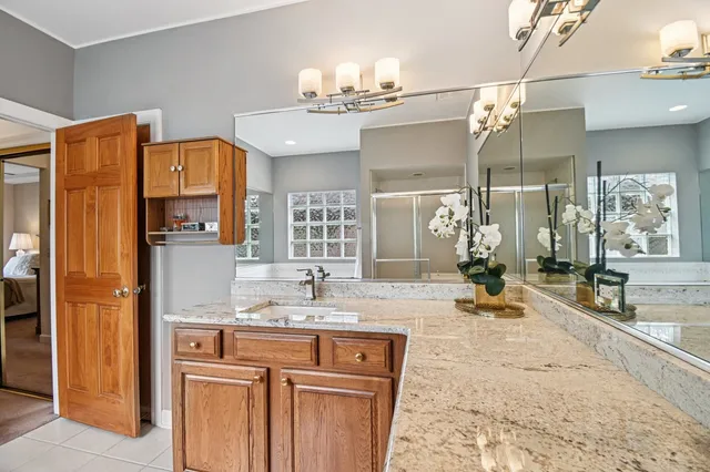 a bathroom with a granite countertop sink a large mirror and a shower