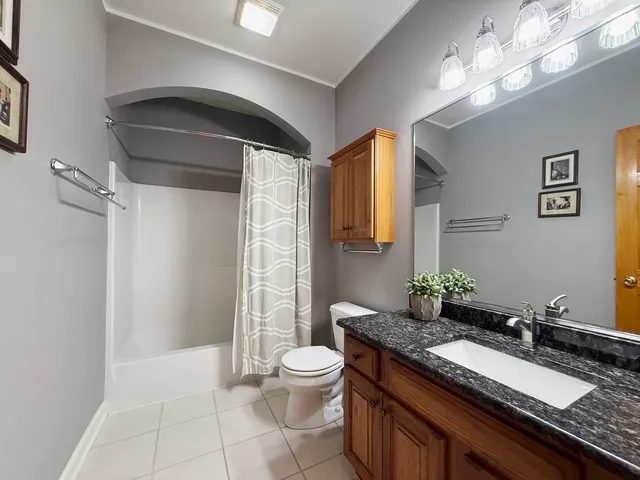 a bathroom with a granite countertop sink a toilet and a mirror