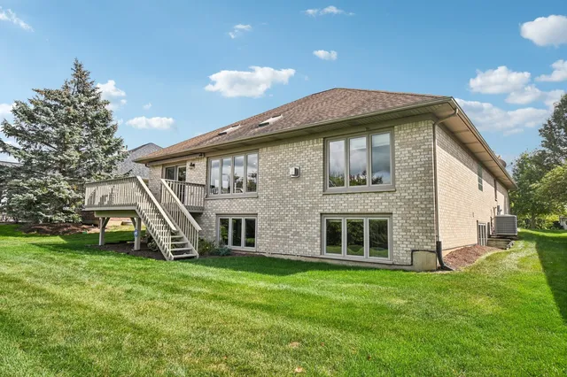 a view of an house with backyard and a tree