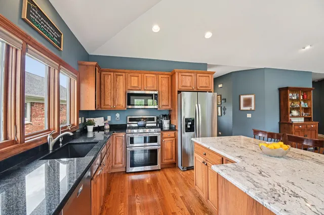 a kitchen with stainless steel appliances granite countertop a sink stove and refrigerator