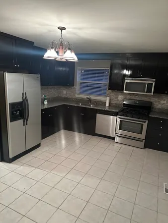 a kitchen with stainless steel appliances granite countertop a sink and a stove
