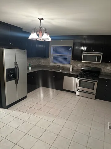 a kitchen with stainless steel appliances granite countertop a sink and a stove