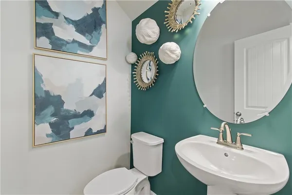 a bathroom with a toilet a sink and mirror