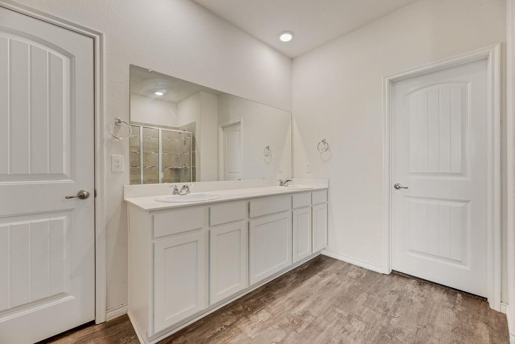633 Bassett Hall Road Fate, TX 75189 - Photo 16 of 20 a bathroom with a double vanity sink and mirror