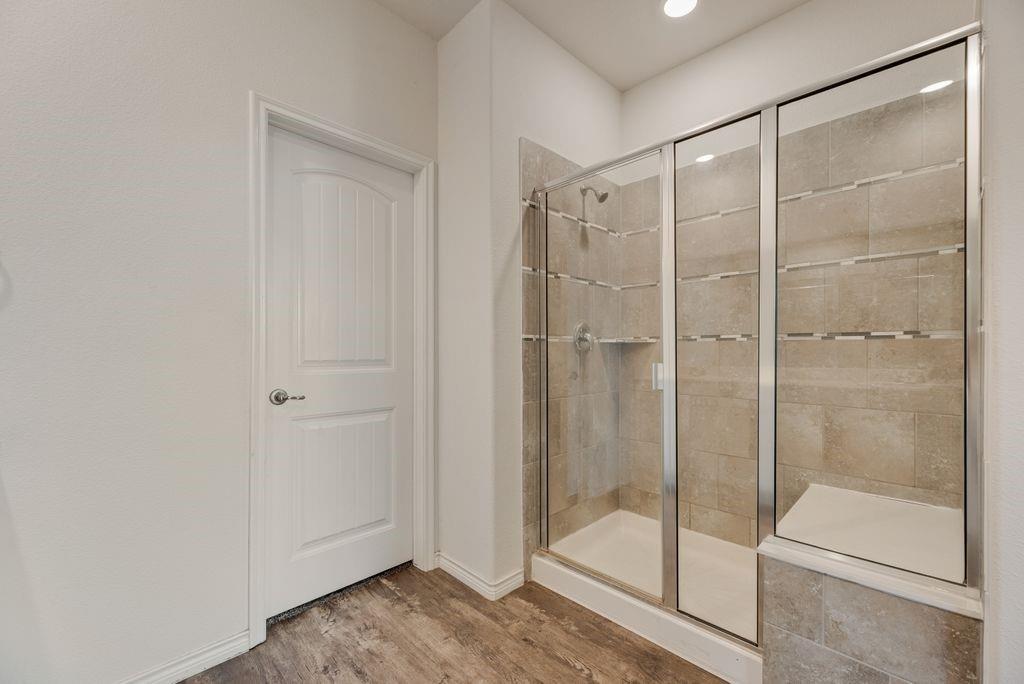 633 Bassett Hall Road Fate, TX 75189 - Photo 17 of 20 a bathroom with a glass shower door
