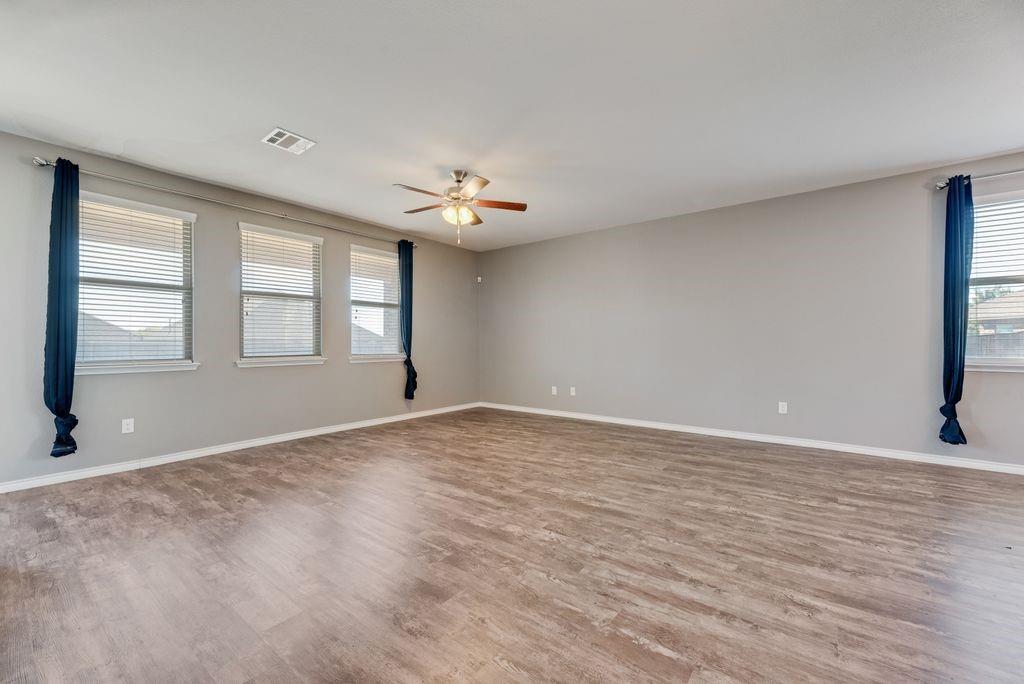633 Bassett Hall Road Fate, TX 75189 - Photo 4 of 20 a view of an empty room with a window and wooden floor