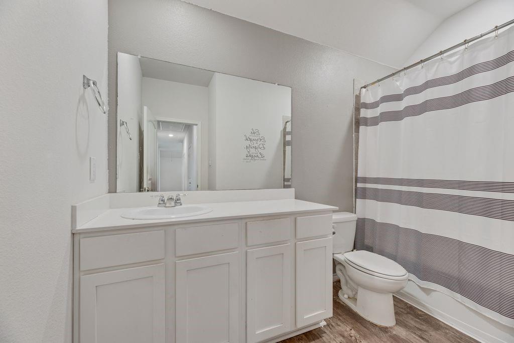 633 Bassett Hall Road Fate, TX 75189 - Photo 7 of 20 a bathroom with a sink a toilet a mirror and shower