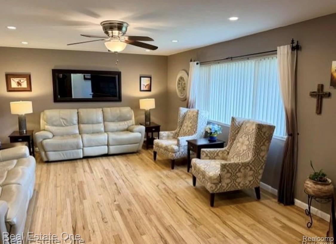 1115 Torpey Road Troy, MI 48083 - Photo 16 of 38 Spacious living area featuring wood-finish flooring, a ceiling fan with integrated lighting, recessed ceiling lights, and large windows with vertical blinds and drapes