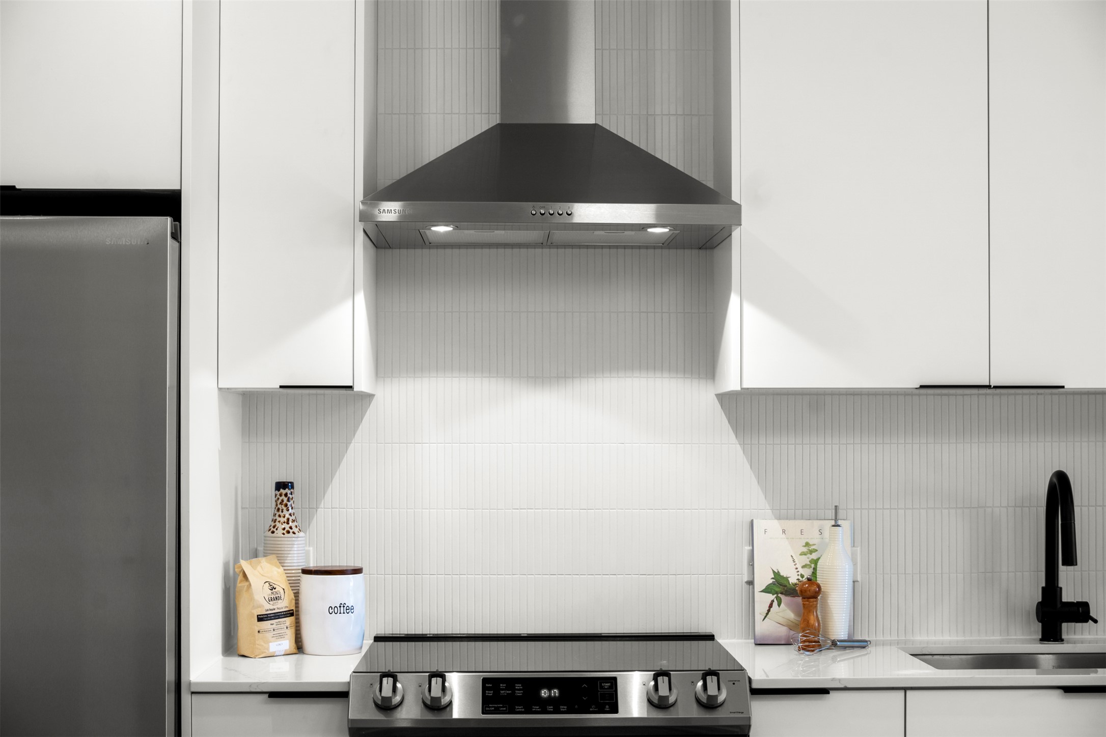 1701 Simond Avenue, Unit 418 Austin, TX 78723 - Photo 6 of 37 Appliances with stainless steel finishes, white cabinetry, and decorative backsplash.