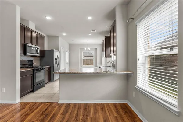 a kitchen with stainless steel appliances granite countertop a refrigerator and a sink