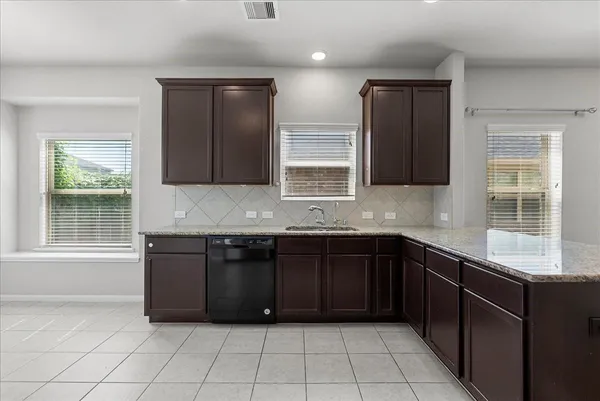 a kitchen with granite countertop a sink and a stove