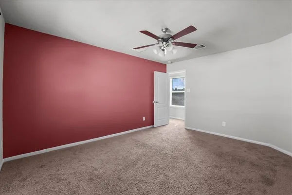 an empty room with a view and a ceiling fan